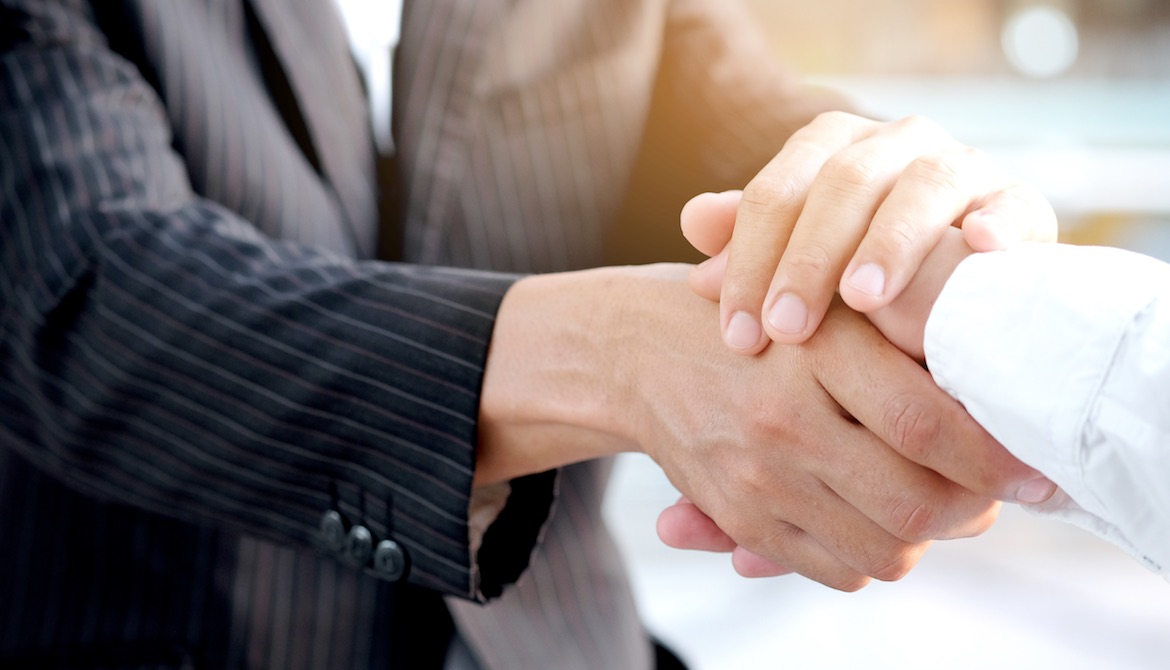 lender warmly shaking hands with business owner