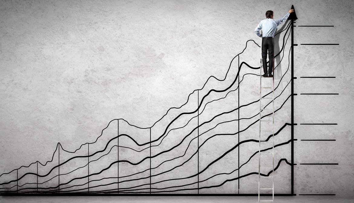 businessman on a ladder drawing financial line graph
