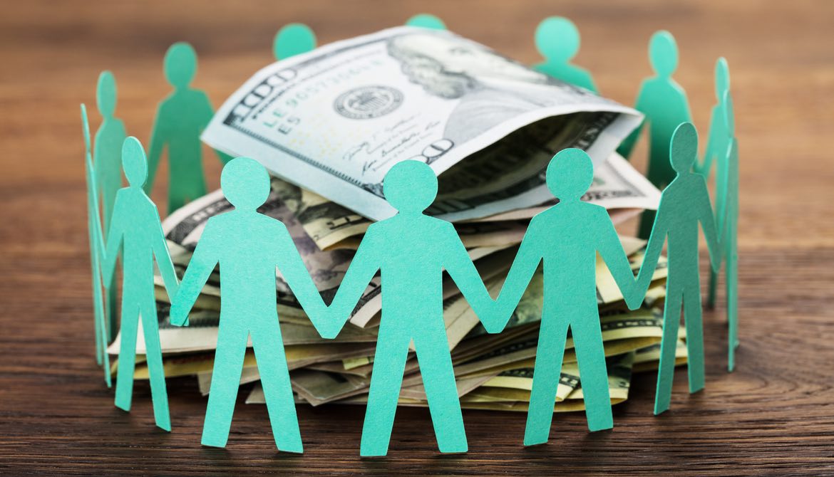 green paper cutout people encircling some money