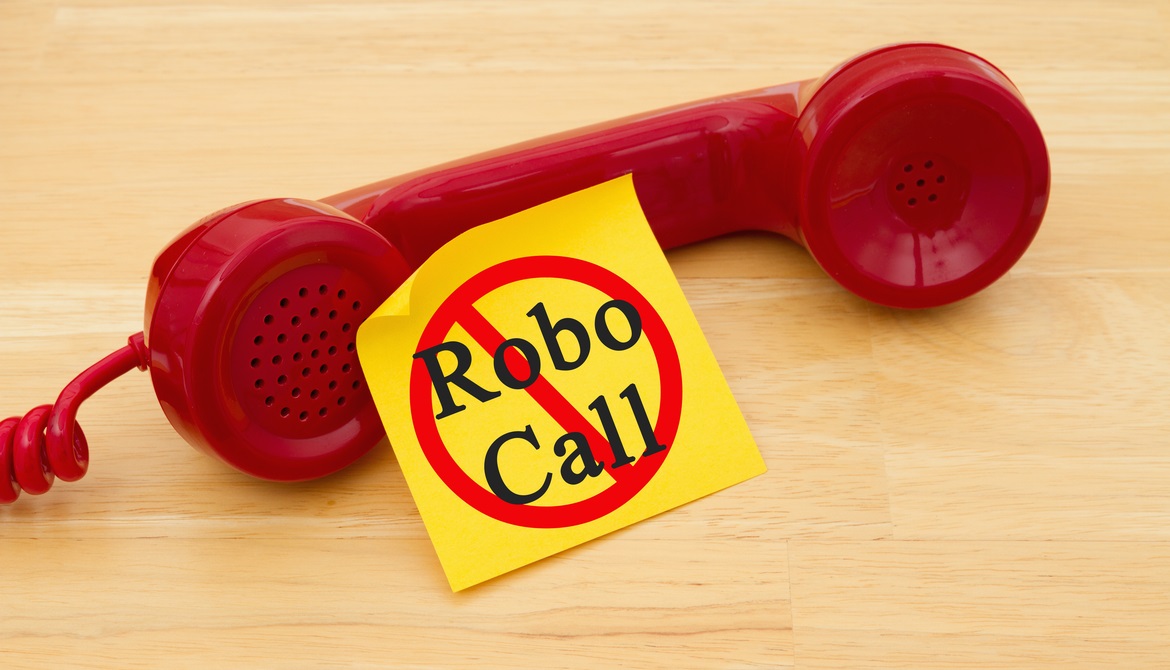 red phone with label robocall on a wooden table
