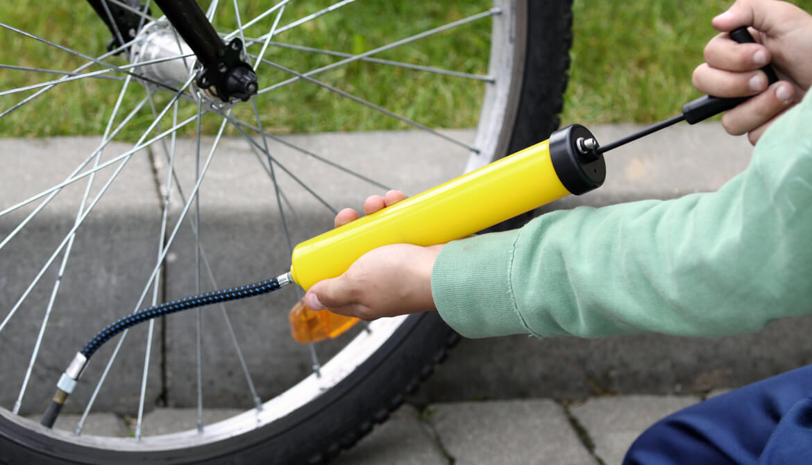 boy pumping up bicycle tire