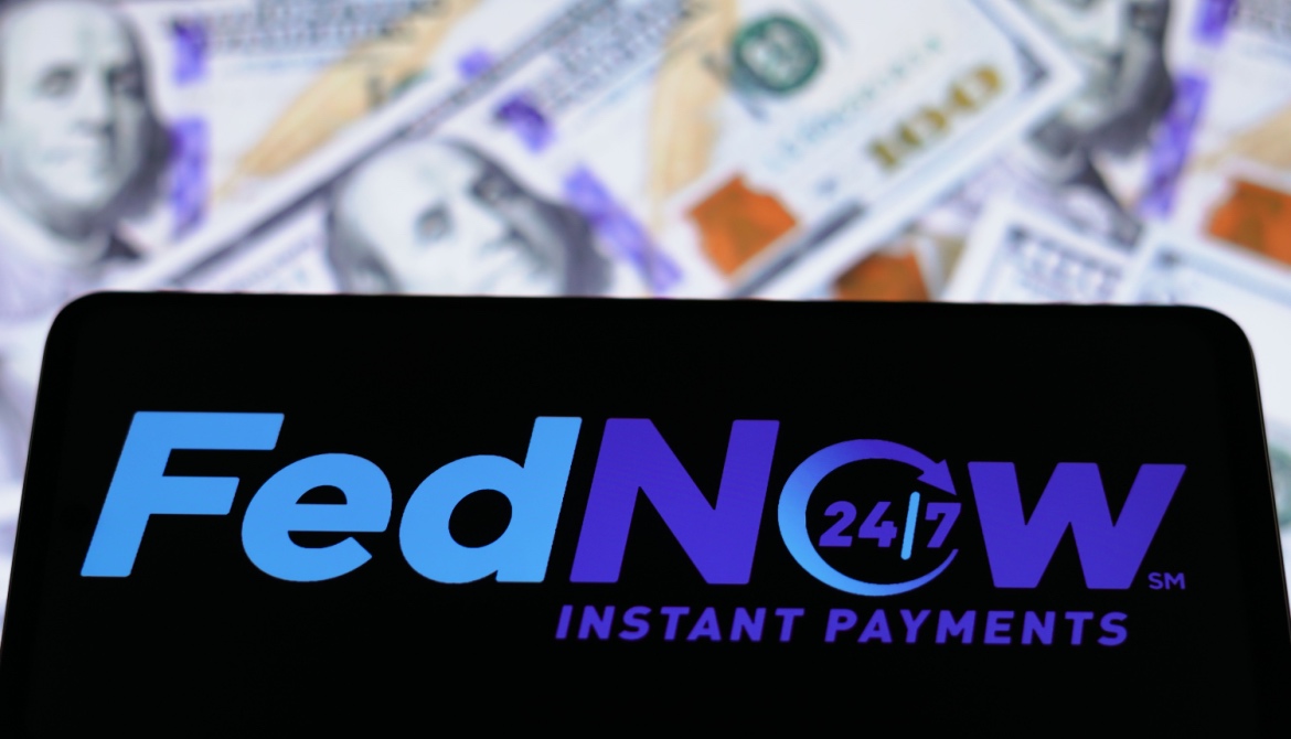 FedNow Service logo seen displayed on a smartphone with hundred dollar bills in background