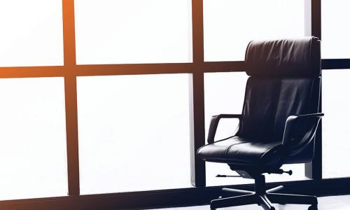 Empty executive chair in front of office window