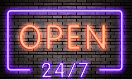 neon sign on a brick wall that reads OPEN 24/7