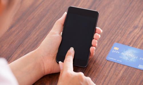 woman using smartphone with credit card to make a payment