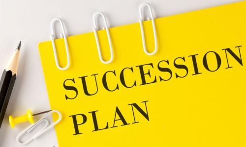 SUCCESSION PlAN word on the yellow paper with office tools on the white background