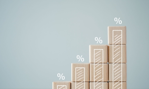 four wooden blocks with growth of bar chart percentage sign