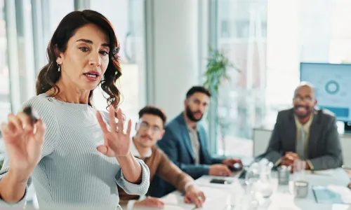 woman explaining to group around table