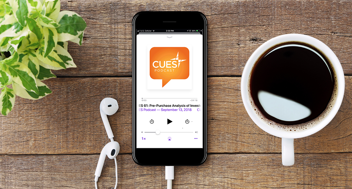 CUES Podcast on a mobile phone next to a cup of coffee