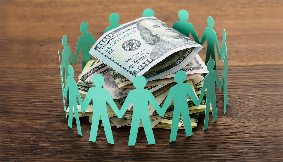 green paper dolls in a circle around cash