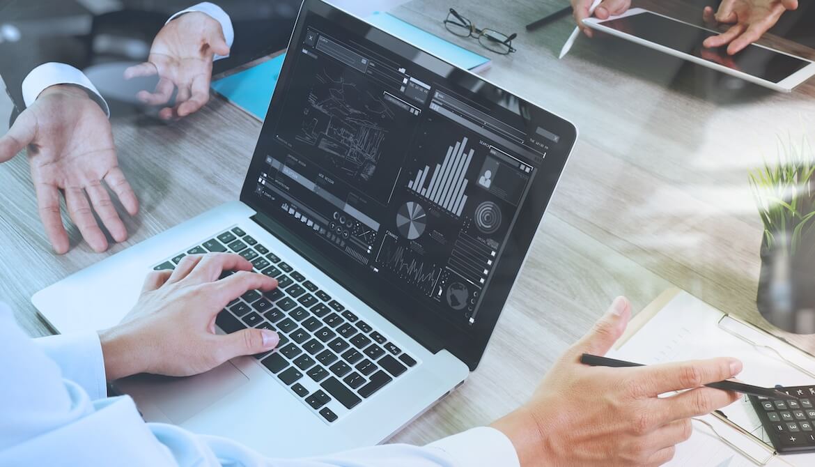 man looking at laptop display of graphical data