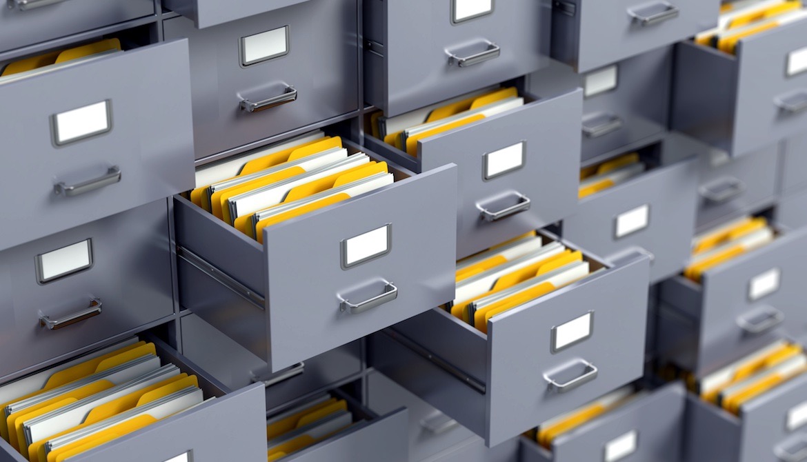 a wall of file cabinets with many open drawers full of folders