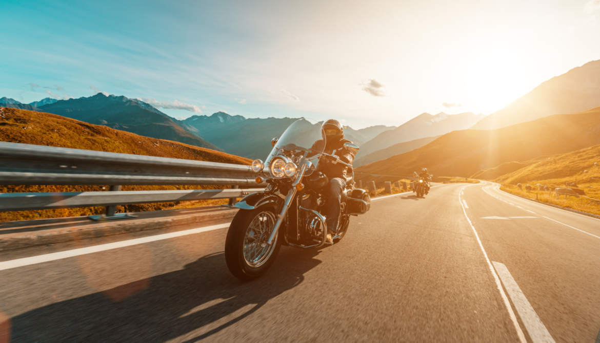 motorcycle rider driving along the open road in front of a friend