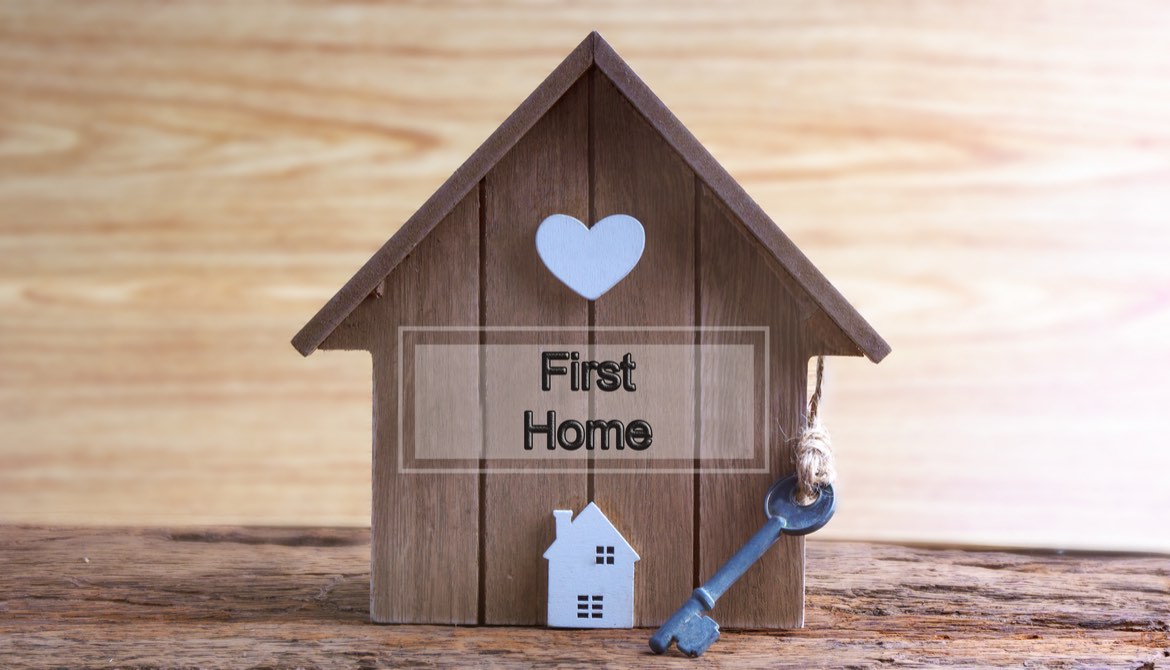 wooden house with a sign that says first home on it