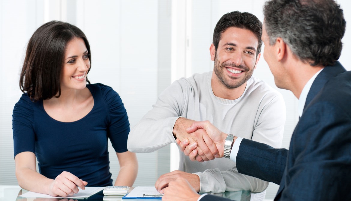 happy member couple shake hands with service representative