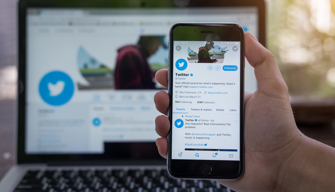 hand holding smartphone displaying Twitter homepage