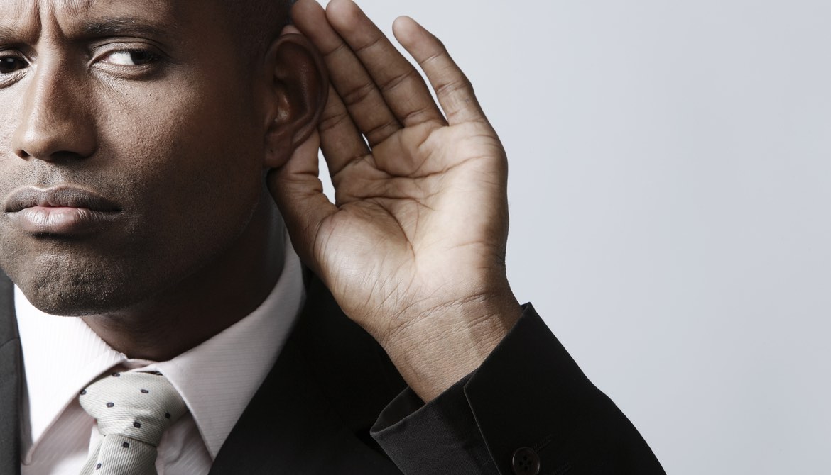 african american business man with his hand to his ear listening