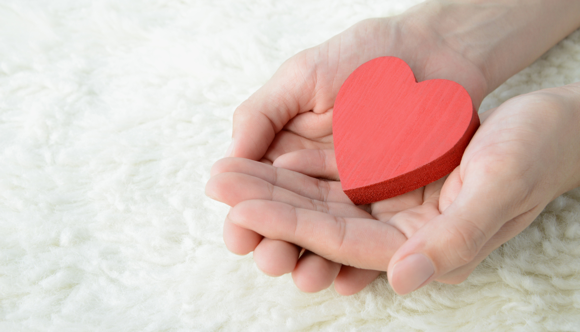 hands holding red wooden hard