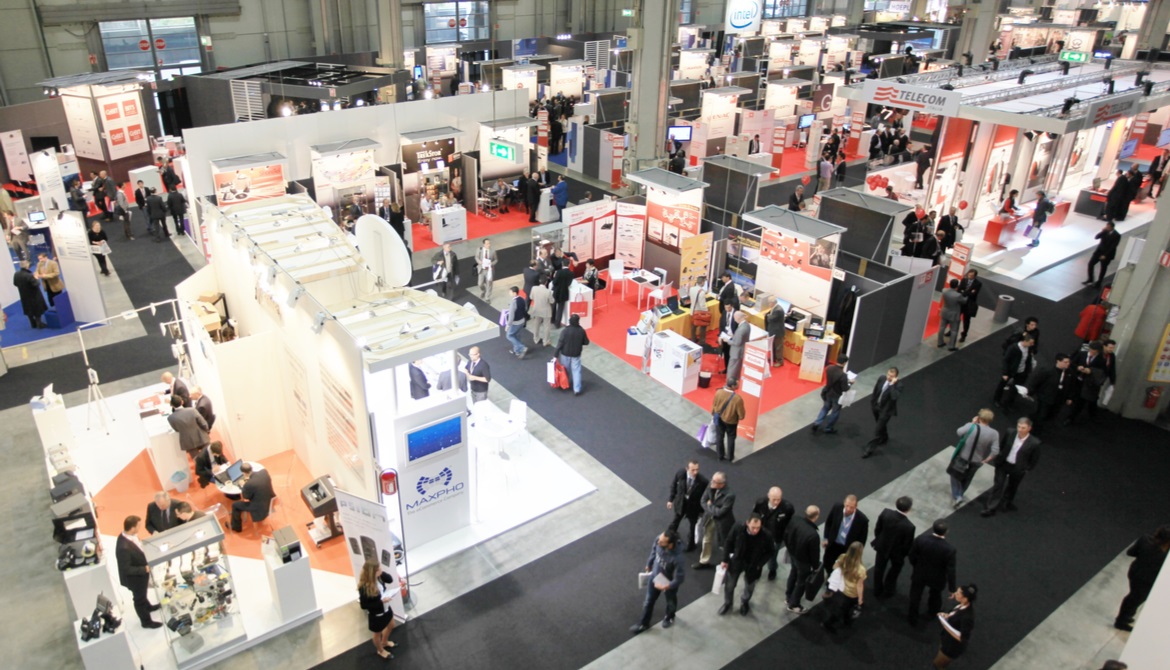 crowds of people visiting booths at a tradeshow