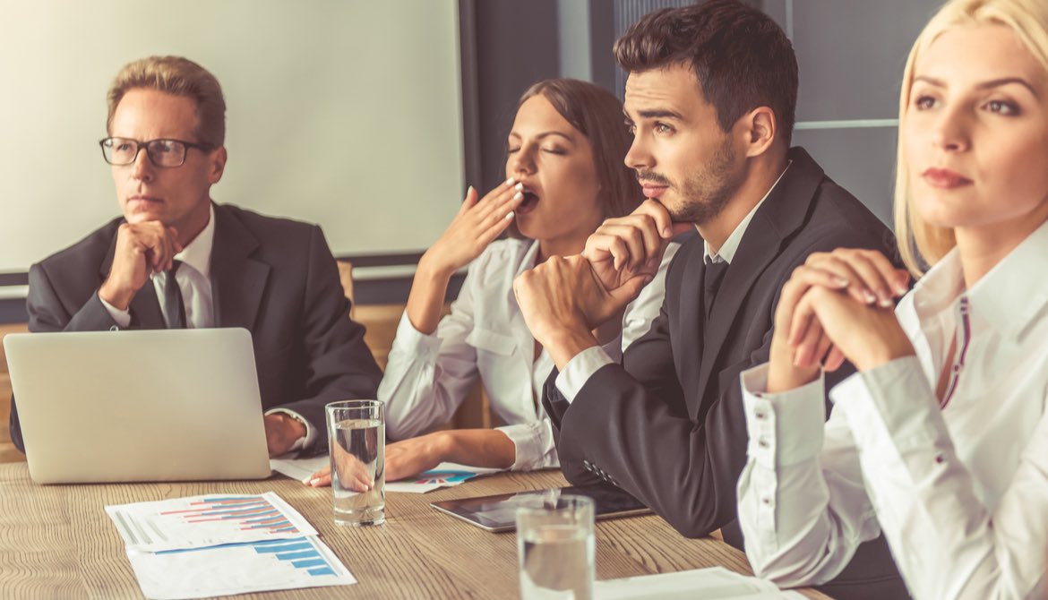 group of directors one of whom is yawning with boredom