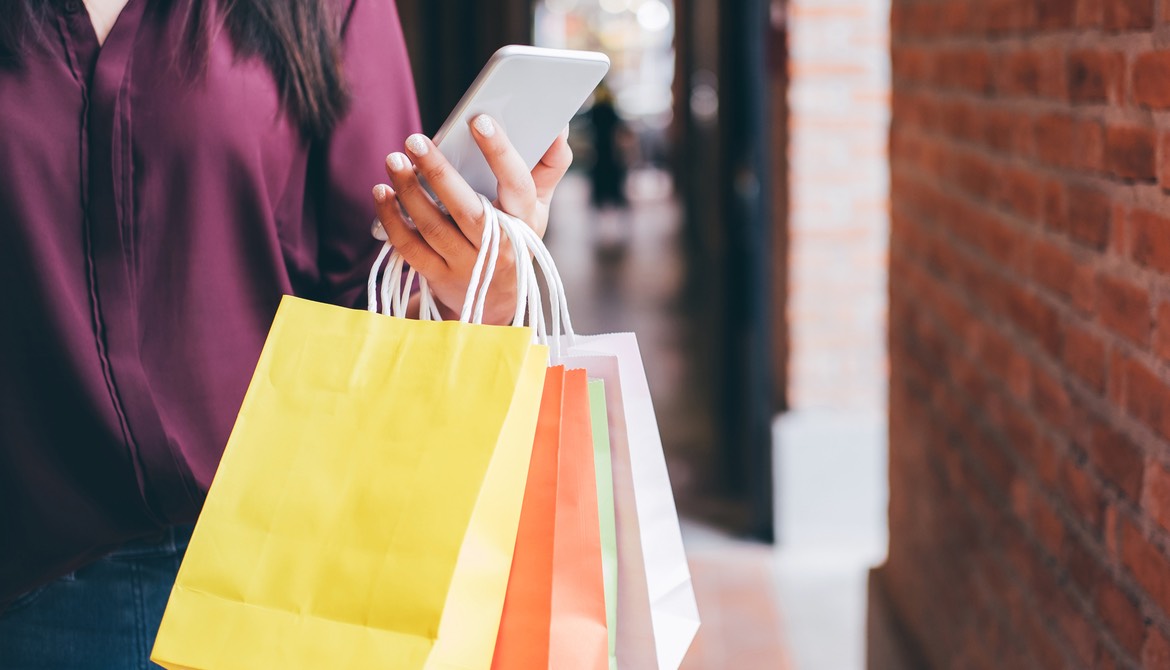 woman with shopping bags and smartphone