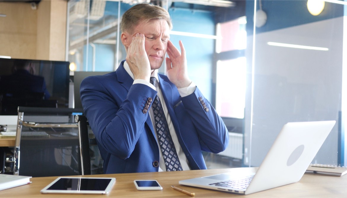 businessman with a headache rubbing his temples