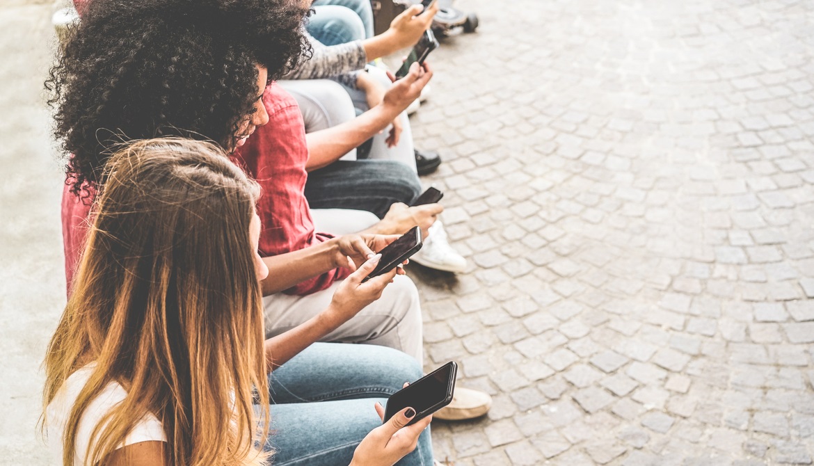 group of young generation z members watching their smartphones