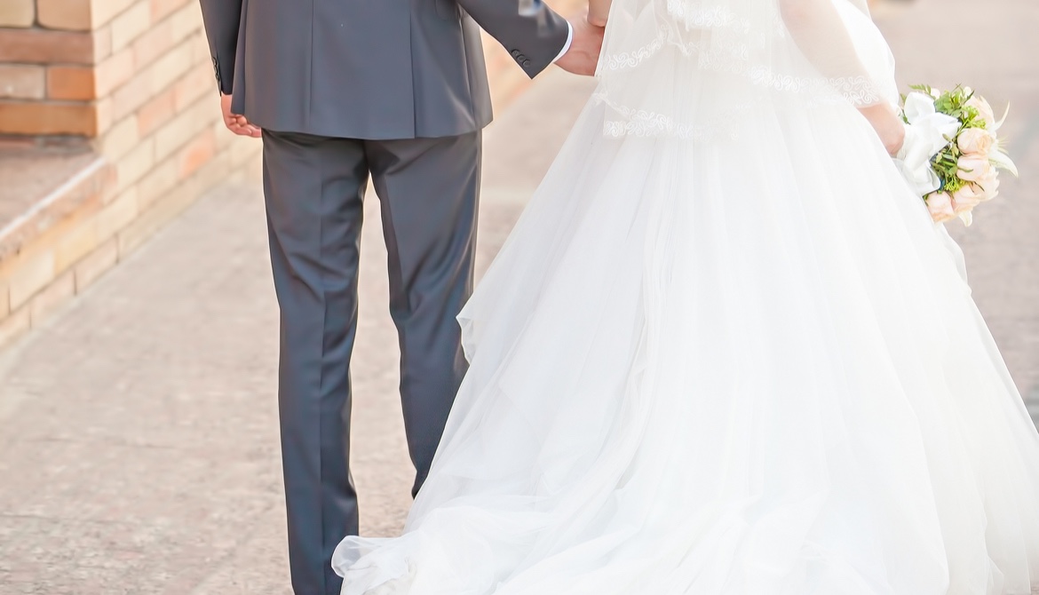 happy bride and groom walking away holding hands