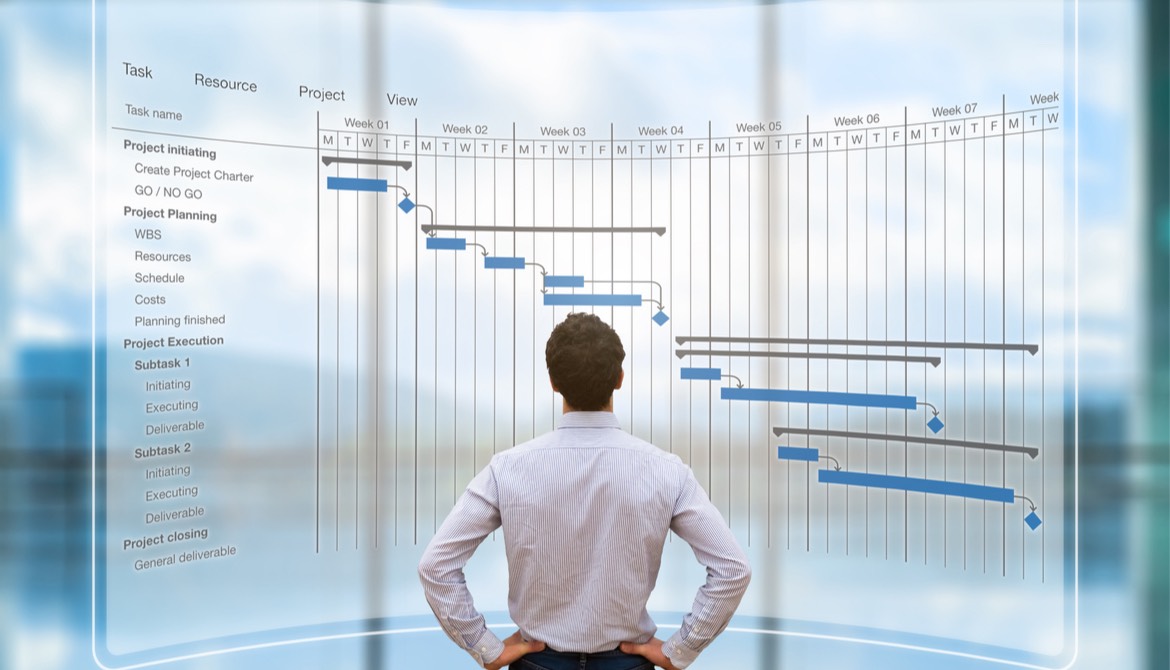 young project manager reviewing a digital Gantt flowchart schedule