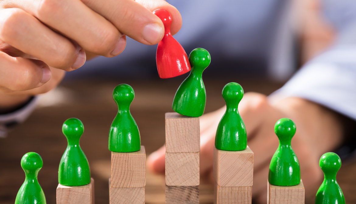 hand replacing one piece in a group of green pawns with a red pawn