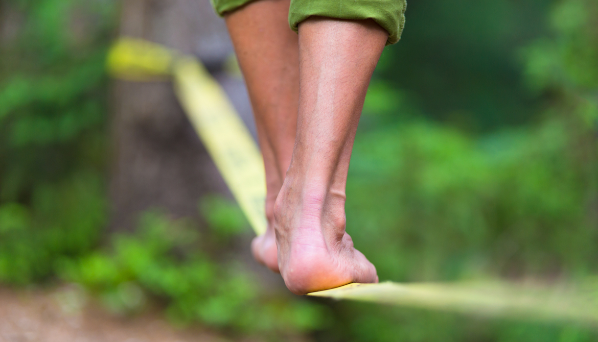 tightrope walker balancing on slack line