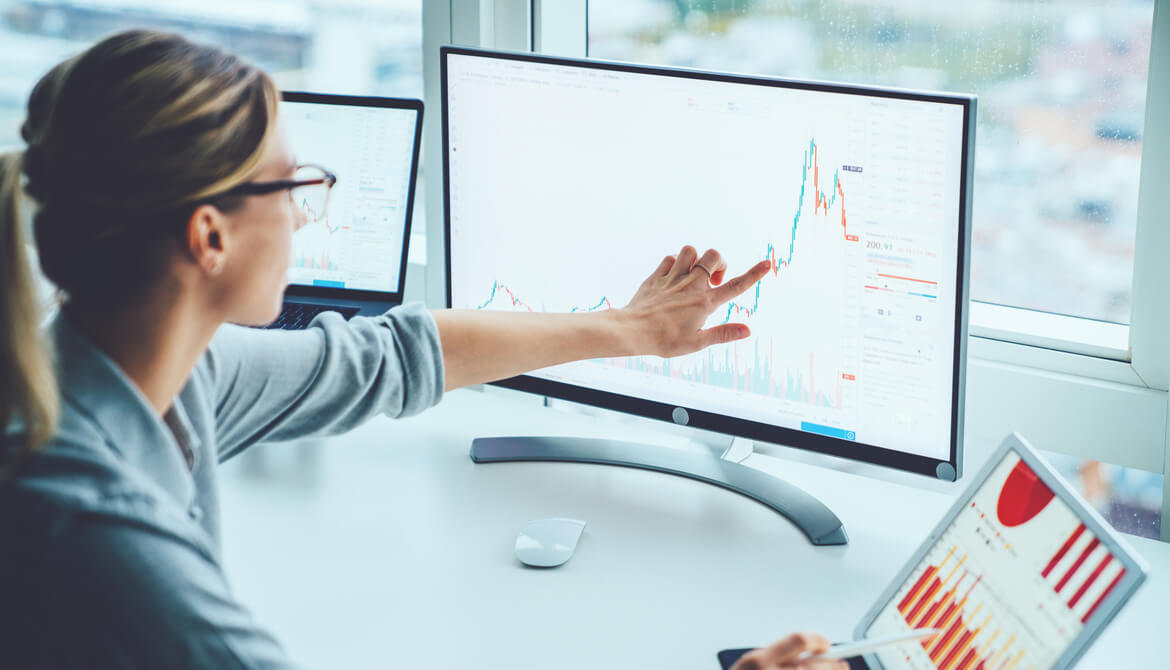 businesswoman using computer and tablet to monitor risks