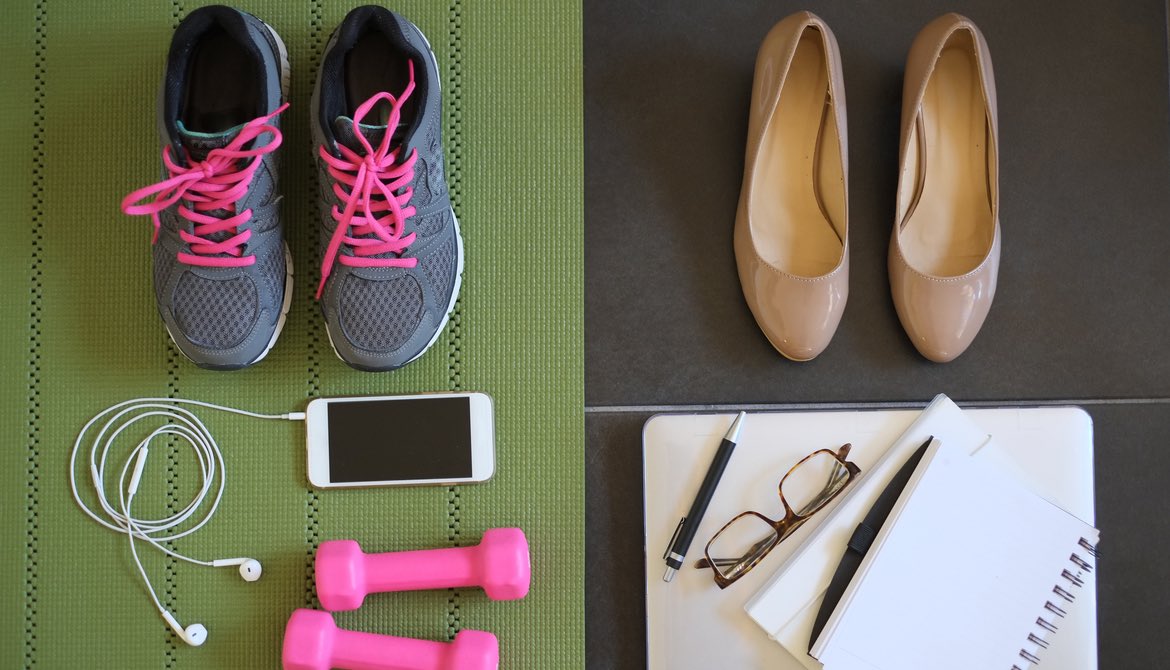workout gear arranged on a green athletic mat next to beige high heel pumps with work notebooks and laptop