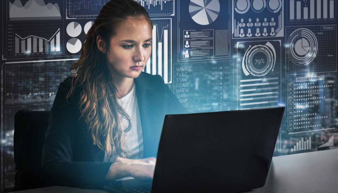 female executive using laptop in front of wall of figures