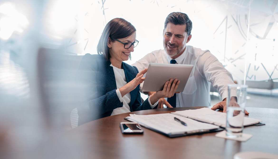 confident business people using tablet at table