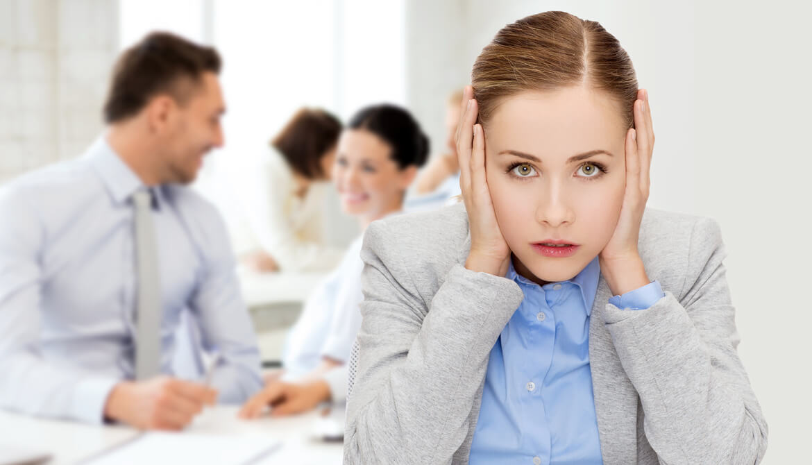 stressed young businesswoman covers her ears in busy office