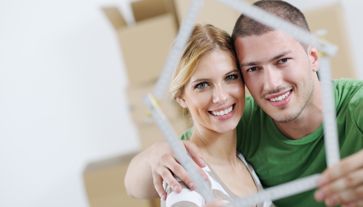 couple look through frame in shape of house