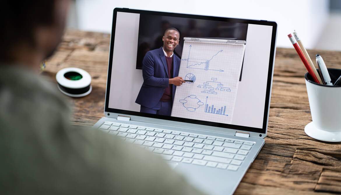 man watches executive present on laptop screen