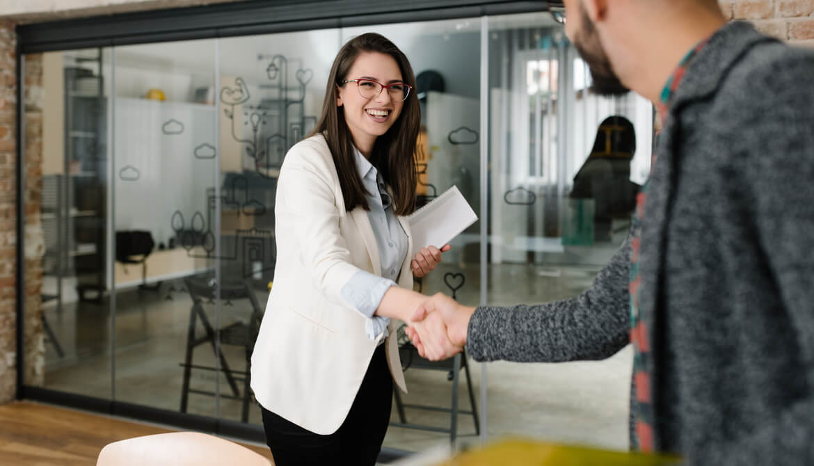 job candidate shakes hands with HR recruiter in pleasant brick office