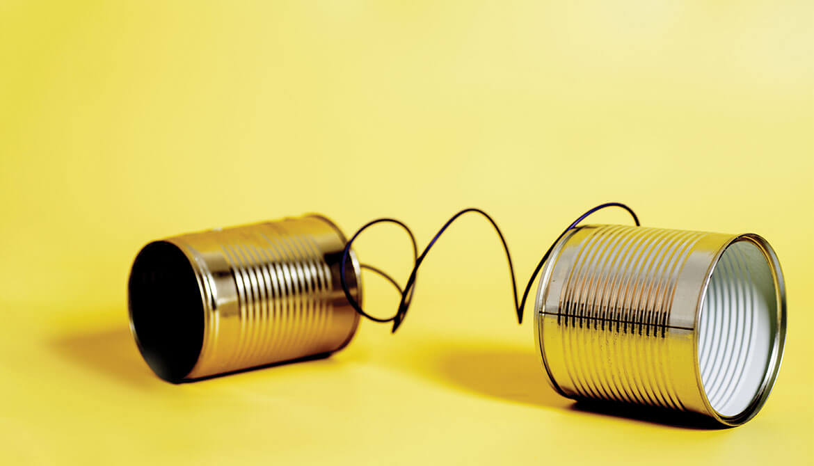 tin-can telephone connected by wire on yellow background