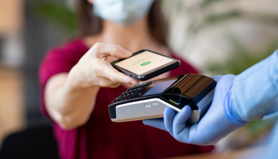 gloved cashier offering credit card reader