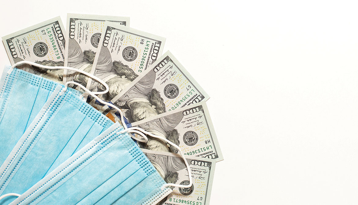 blue disposable face masks fanned out over 100 dollar bills