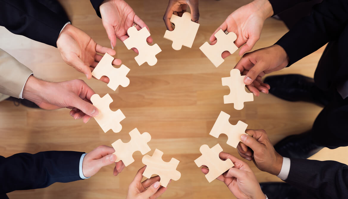 diverse business people put puzzle pieces together