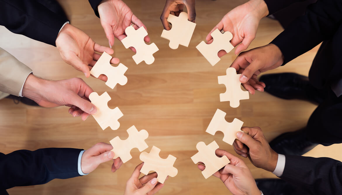diverse business people put puzzle pieces together