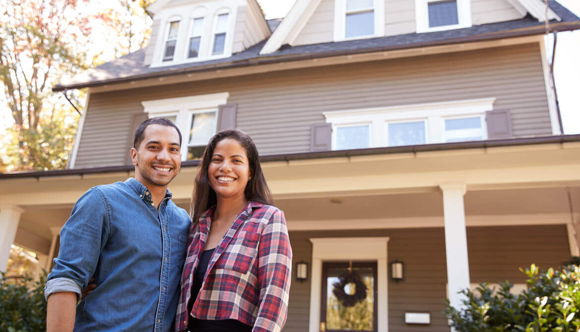 couple standing in front of home