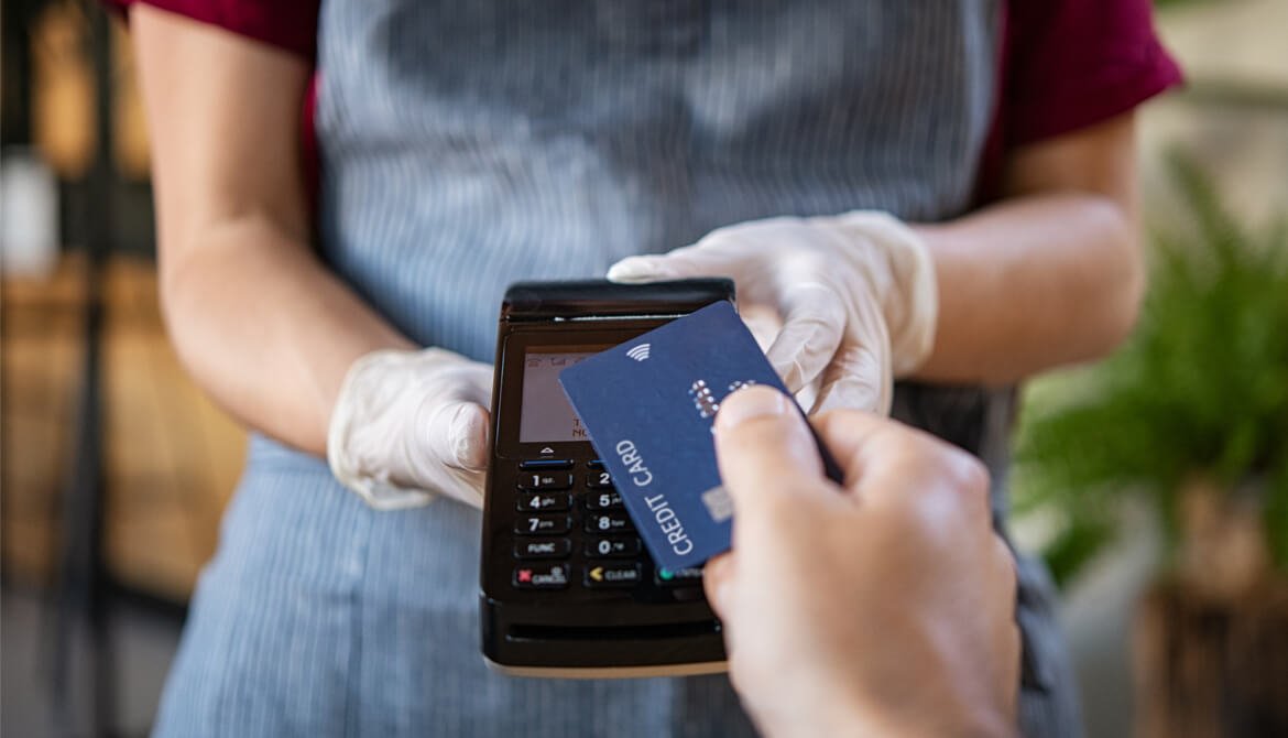 waitress with contactless card reader accepting payment from customer