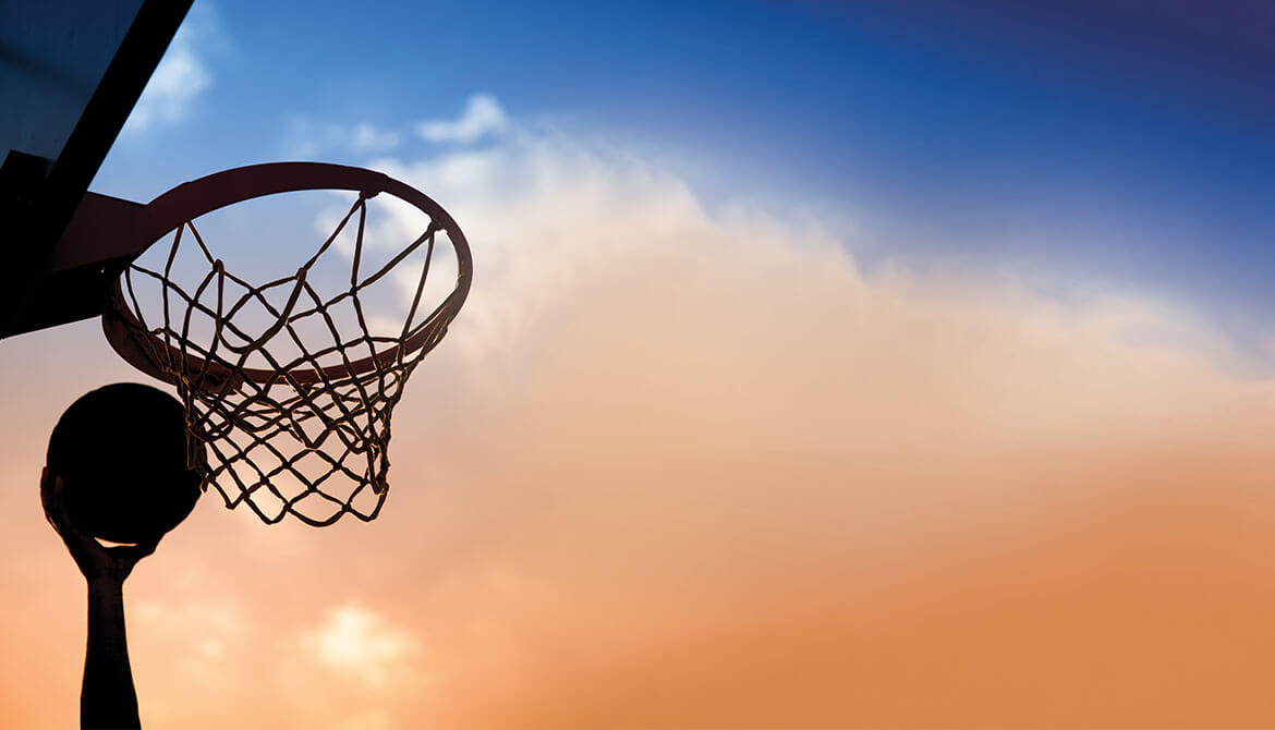 hand reaching up to catch basketball rebounding off backboard