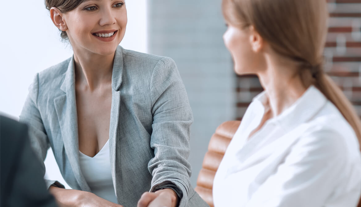 female manager shaking hand to congratulate female employee