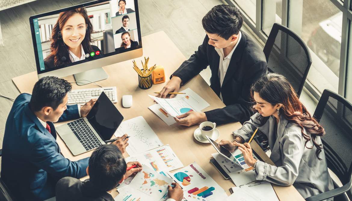 conference call with female leader on computer screen at the table