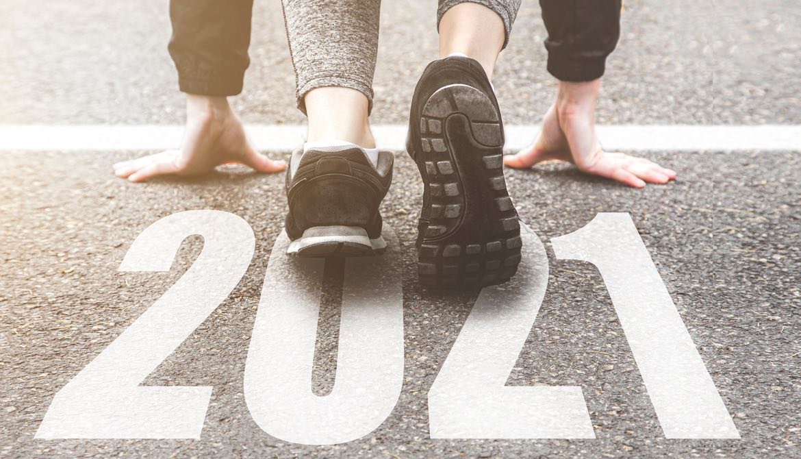 runner in black sneakers crouched at 2021 starting line